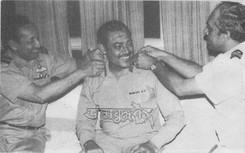 খালেদ মোশাররফকে সেনাপ্রধানের ব্যাজ পড়াচ্ছেন বিমান বাহিনী প্রধান এমএজি তোয়াব (বায়ে) ও নৌবাহিনী প্রধান এমএইচ খান